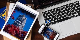 a laptop, an ipad, and an iphone scattered on a desk