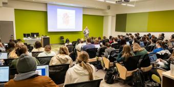 a class full of students listening to a lecture