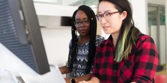 two women looking at a computer screen