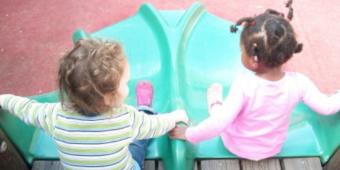 two children on top of a slide at ucdc