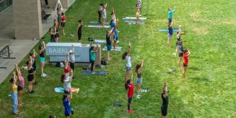 a group of people do yoga outside the baierl recreation center